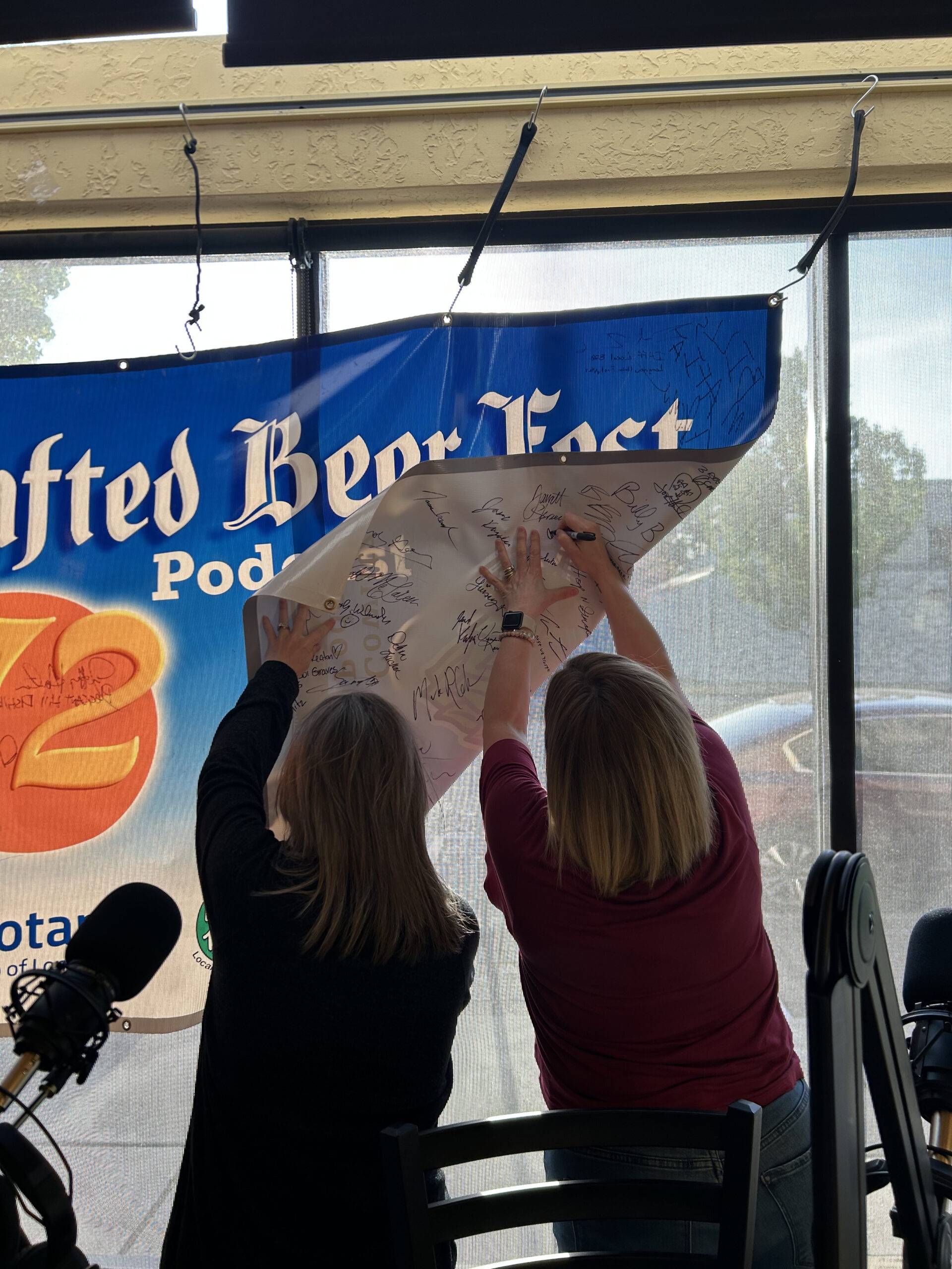 Debi Trull and Amy McMahon from the Lower Columbia Association of Realtors Signing the Crafted beer fest podcast Banner