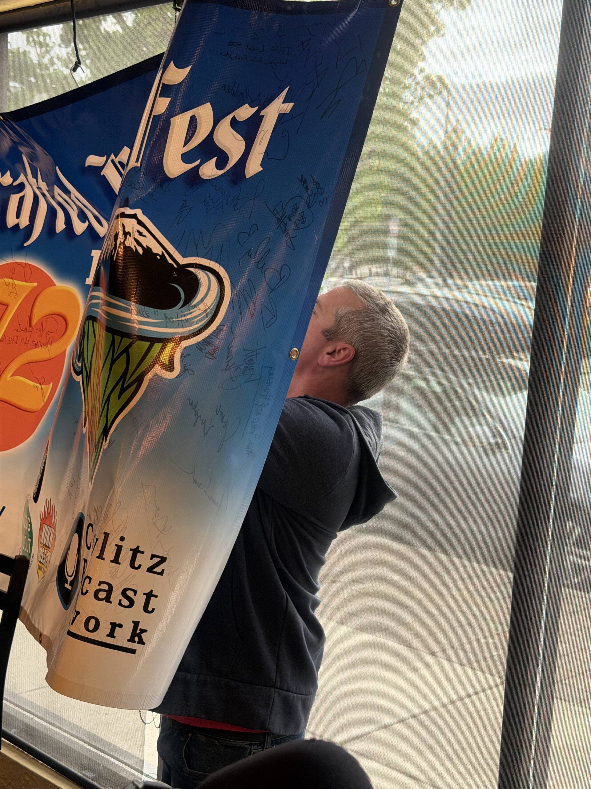 Jamey Jensen signing the crafted podcast banner